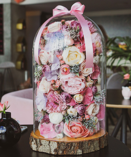 Mix of artificial flowers in a glass dome